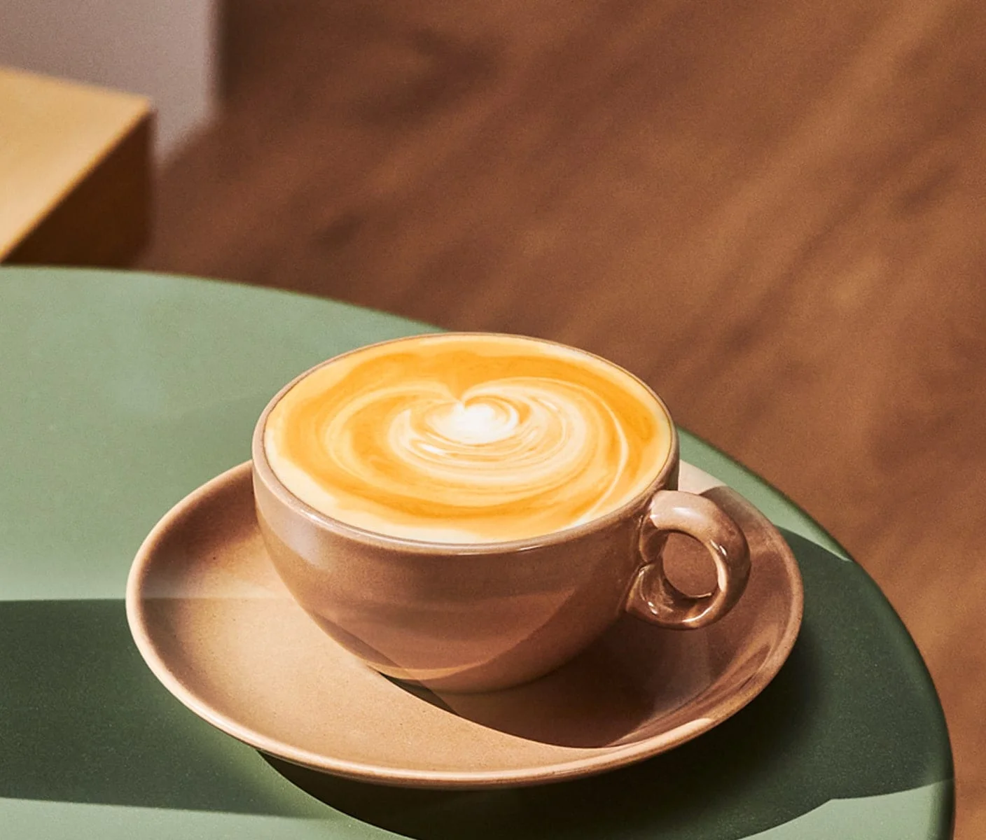 Warm, inviting photo of a creamy Starbucks Caramel Protein Latte in a clear cup, topped with swirls of caramel drizzle. Try this tasty boost!